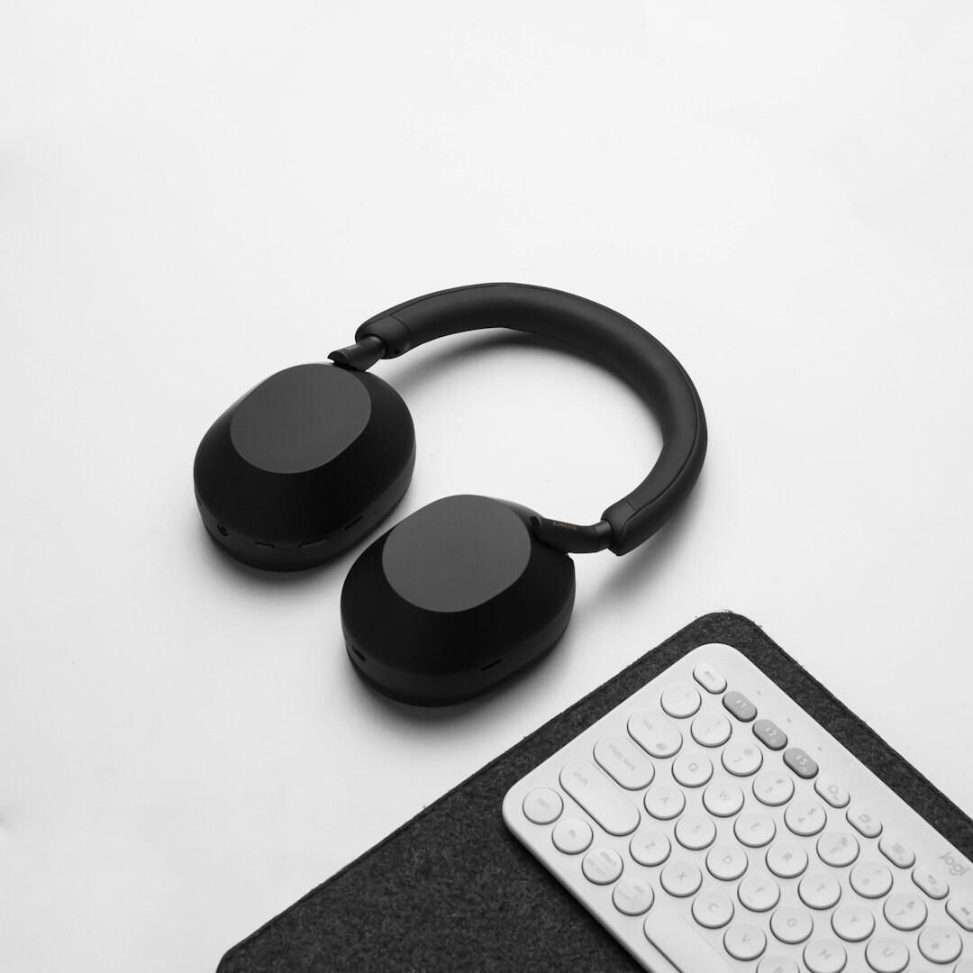 Pair of studio headphones resting on a desk beside a notebook