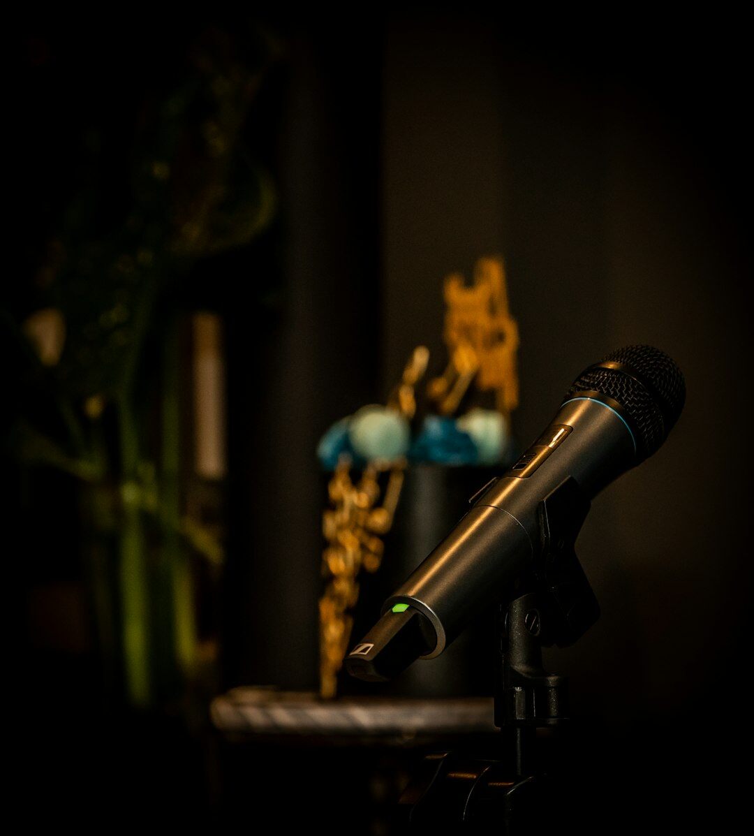 South African podcast host wearing headphones speaking into a microphone in a recording studio